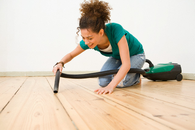 Woman Vacuuming Hardwood Floor --- Image by © Stefanie Grewel/Corbis